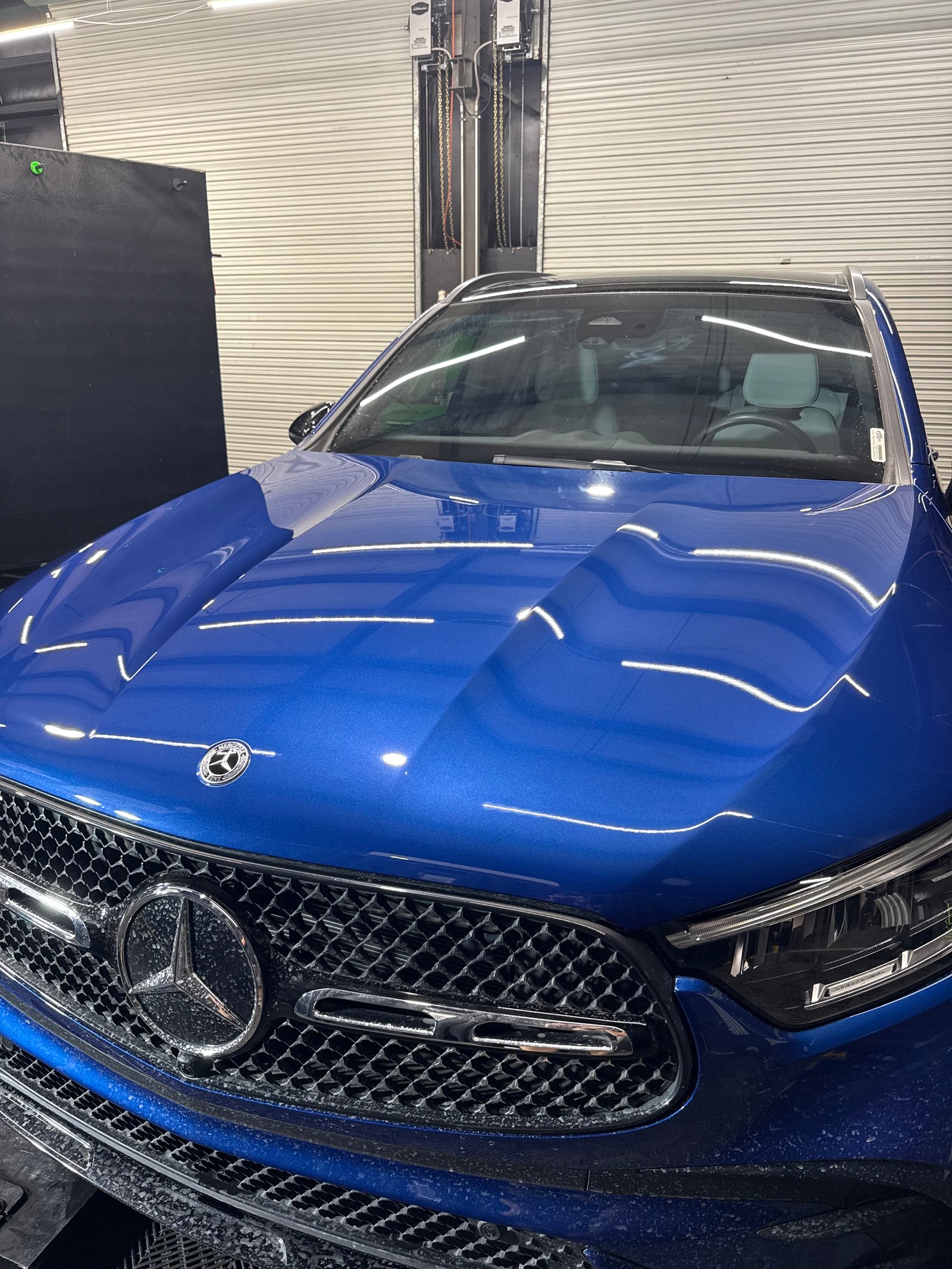 A close up of a glossy black car with a brilliant shine.