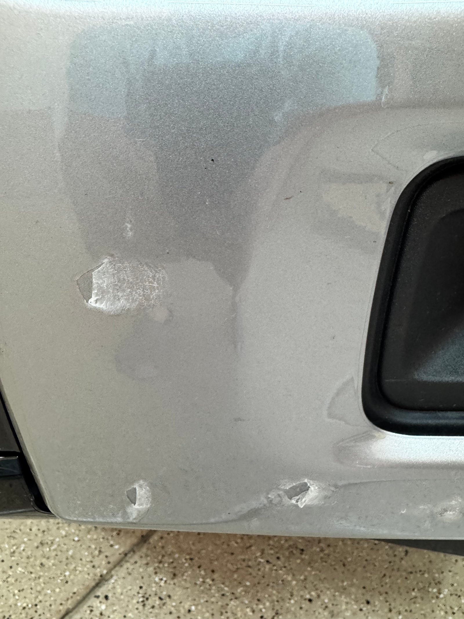PPF film showing rock chip damage from highway impact — paint underneath protected